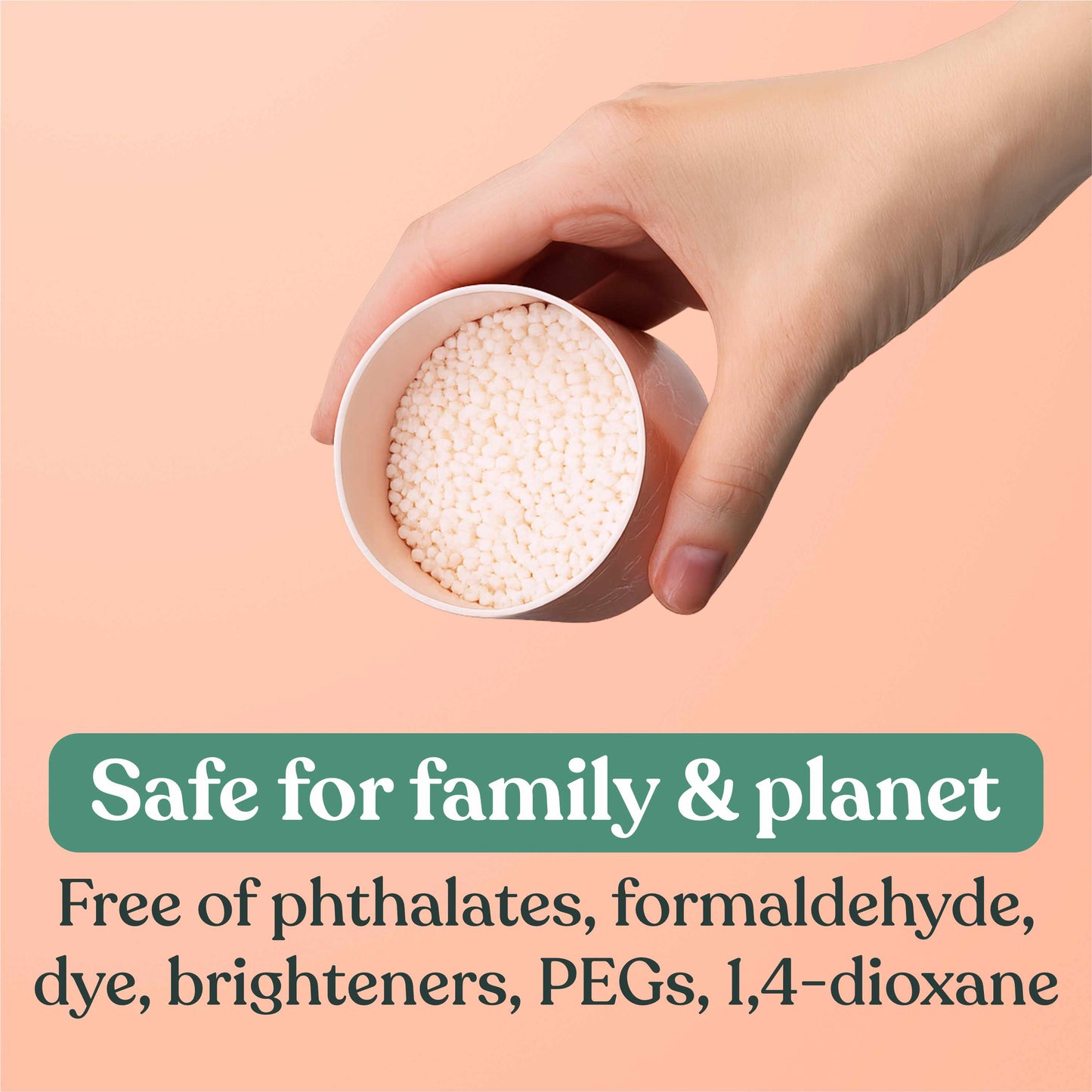 Hand holding a small container of white fragrance booster beads with text about product safety on a peach background