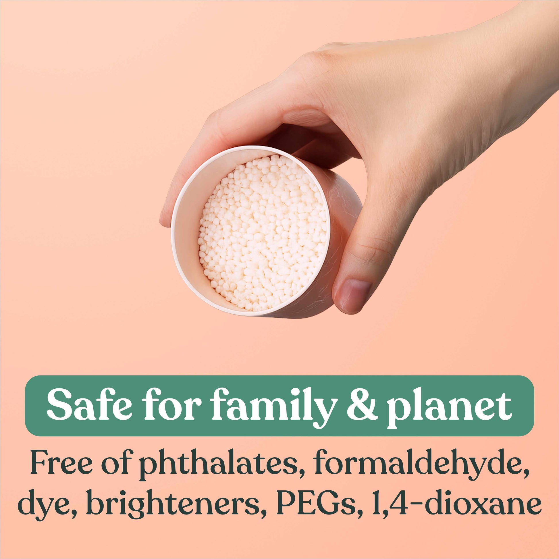 Hand holding a small container of white fragrance booster beads with text about product safety on a peach background