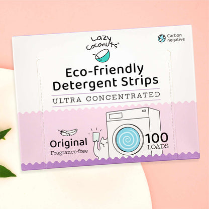Lazy Coconuts Eco-Friendly Detergent Strips 100 Loads packaging box, featuring a white and pastel pink design with illustrations of a coconut and a washing machine, set against a soft pink background.